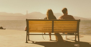 couple sitting on bench looking away from eachother